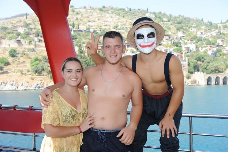 Alanya pirate boat tour entertainers posing with tourists on deck